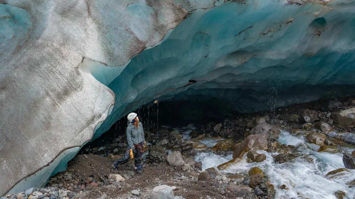 A small roped group crossing a ridge of ancient ice on the Long Adventure Skaftafell glacier hike below the Falljökull icefall, Iceland